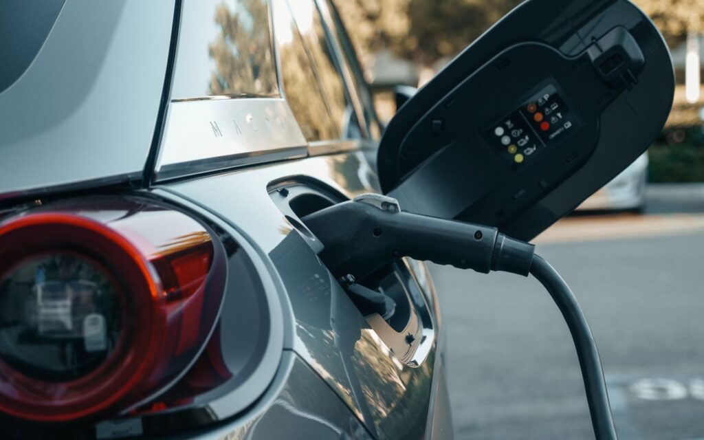 Närbild på bil som laddas – skillnaden mellan hybridbil, laddhybrid och elbil