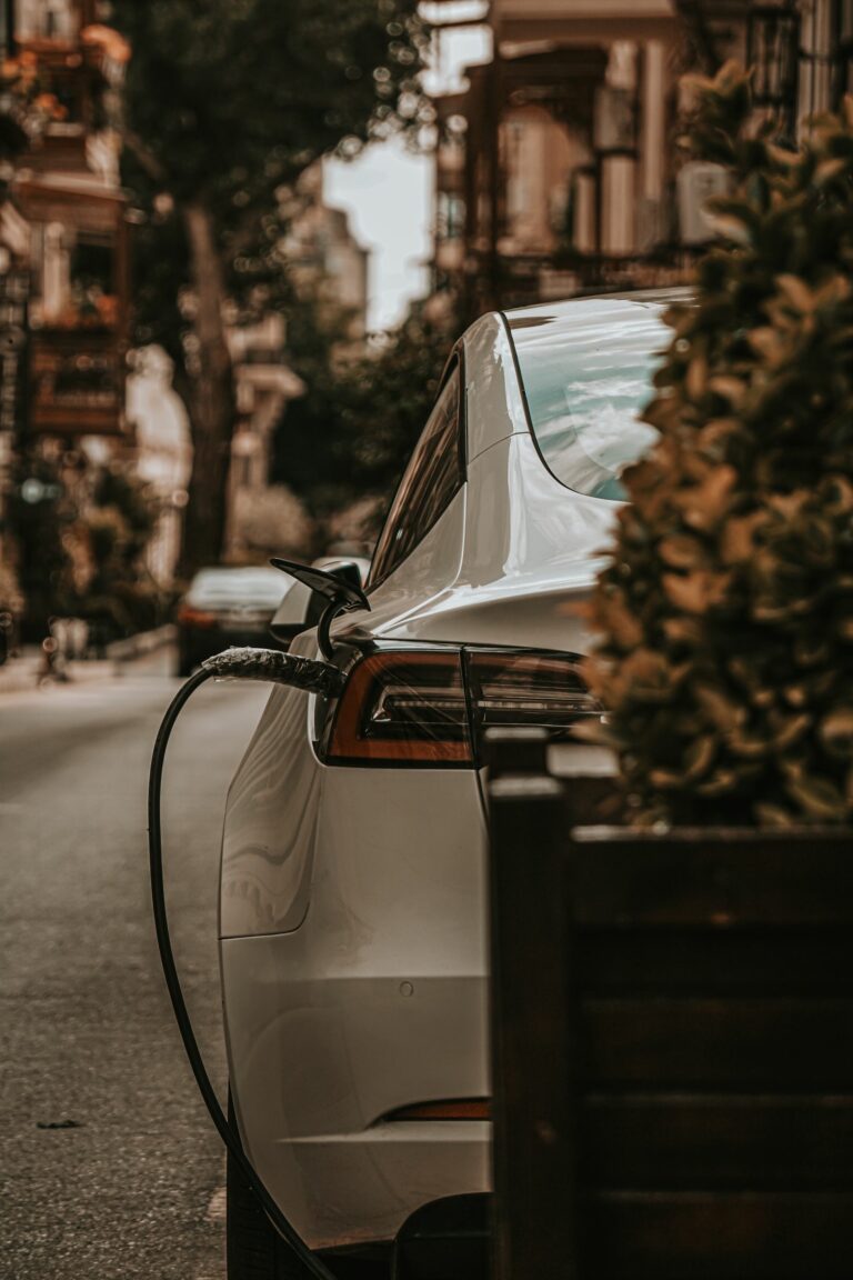 Elbil som laddas vid modern laddstation – relevant för laddhybrid och pendling